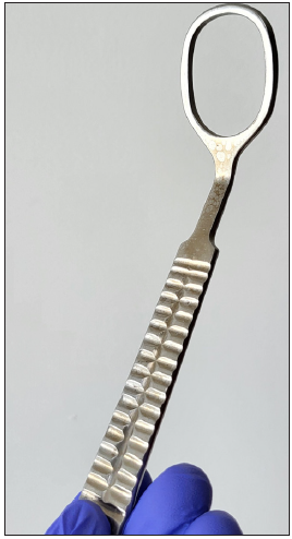 Stainless steel skin clamp with a grooved shaft handle, a tapering neck and an oblong fixing ring inclined at 135° at the distal end, which provides a wide view of the operating field. The inclination helps in better positioning and grip of the fixing ring onto the target surface.